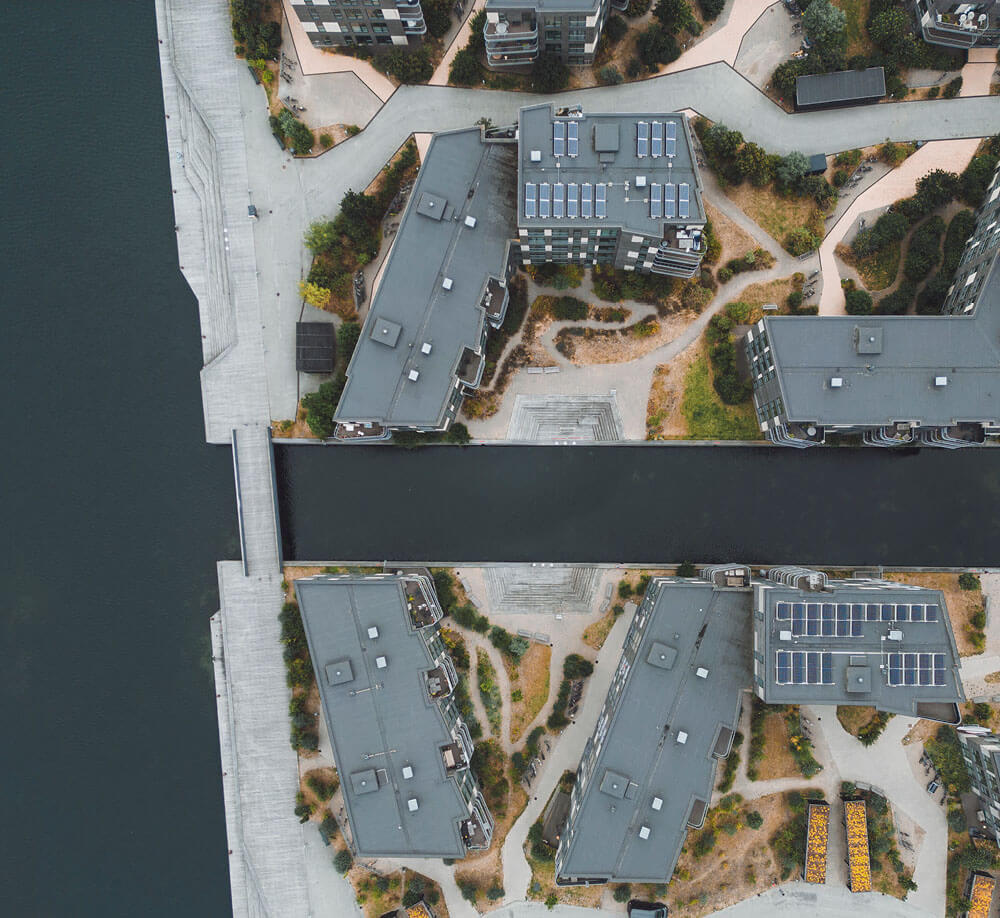 Aerial view of a residential neighborhood featuring multiple solar panels on rooftops.